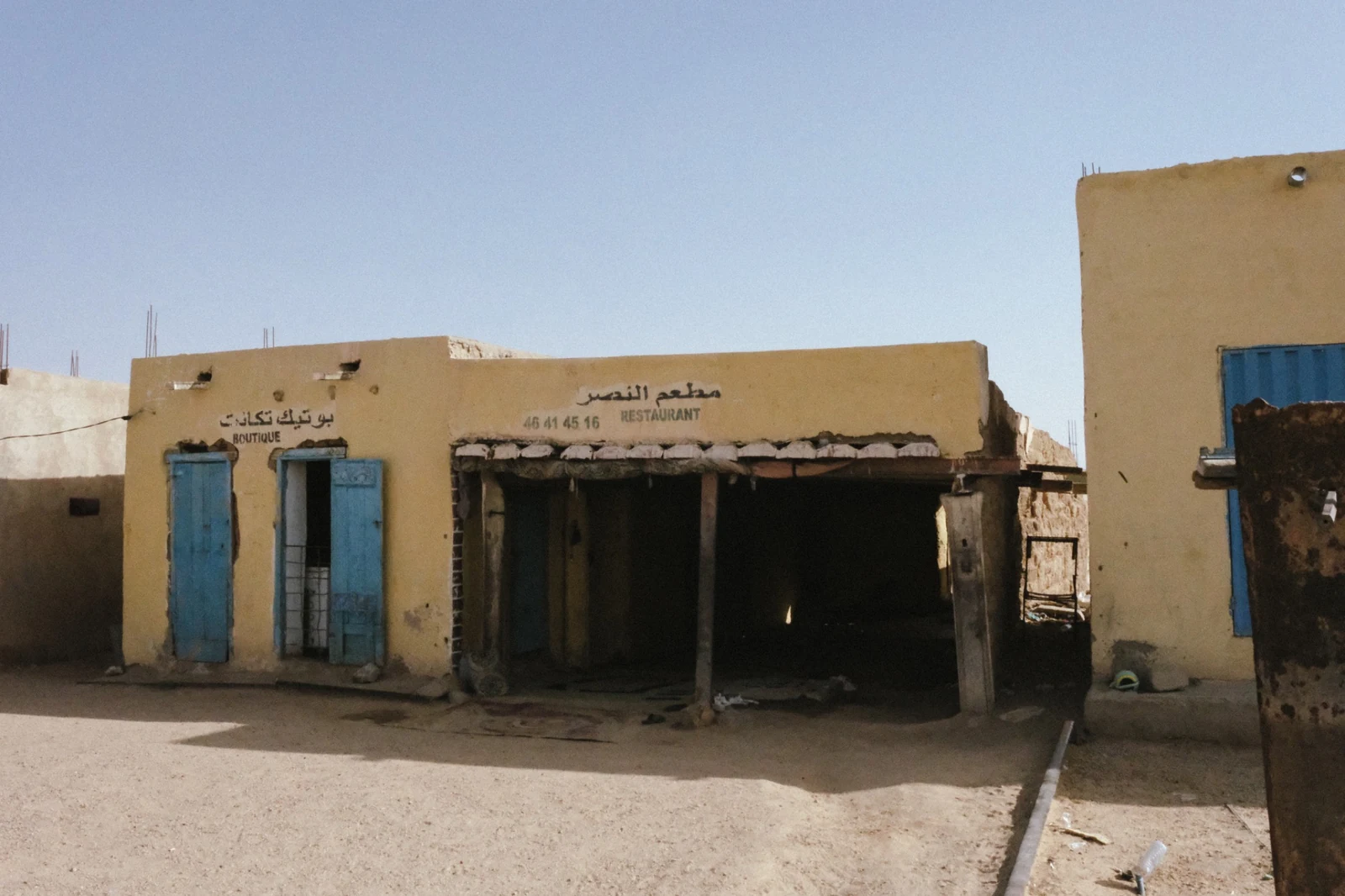 Low buildings and shopfronts beside the railway at Choum.