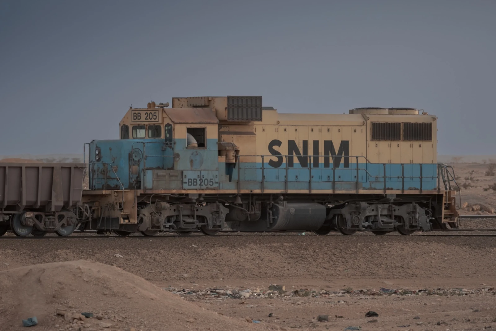 SNIM locomotive BB 205, with faded blue and cream paint, coupled to ore wagons.