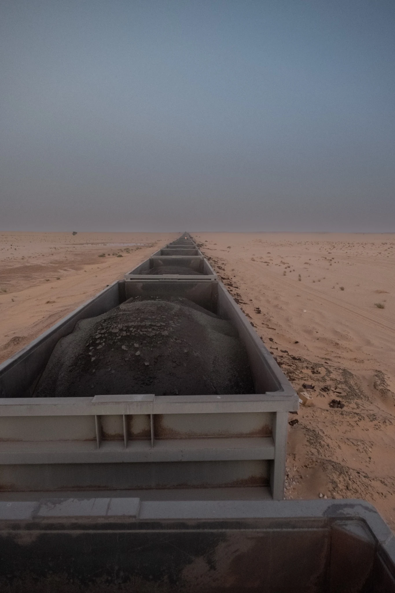 View from inside the train over the iron ore in open wagons stretching into the distance.