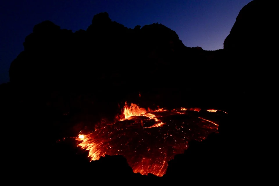 Active lava illuminating the summit crater of Erta Ale after dark.