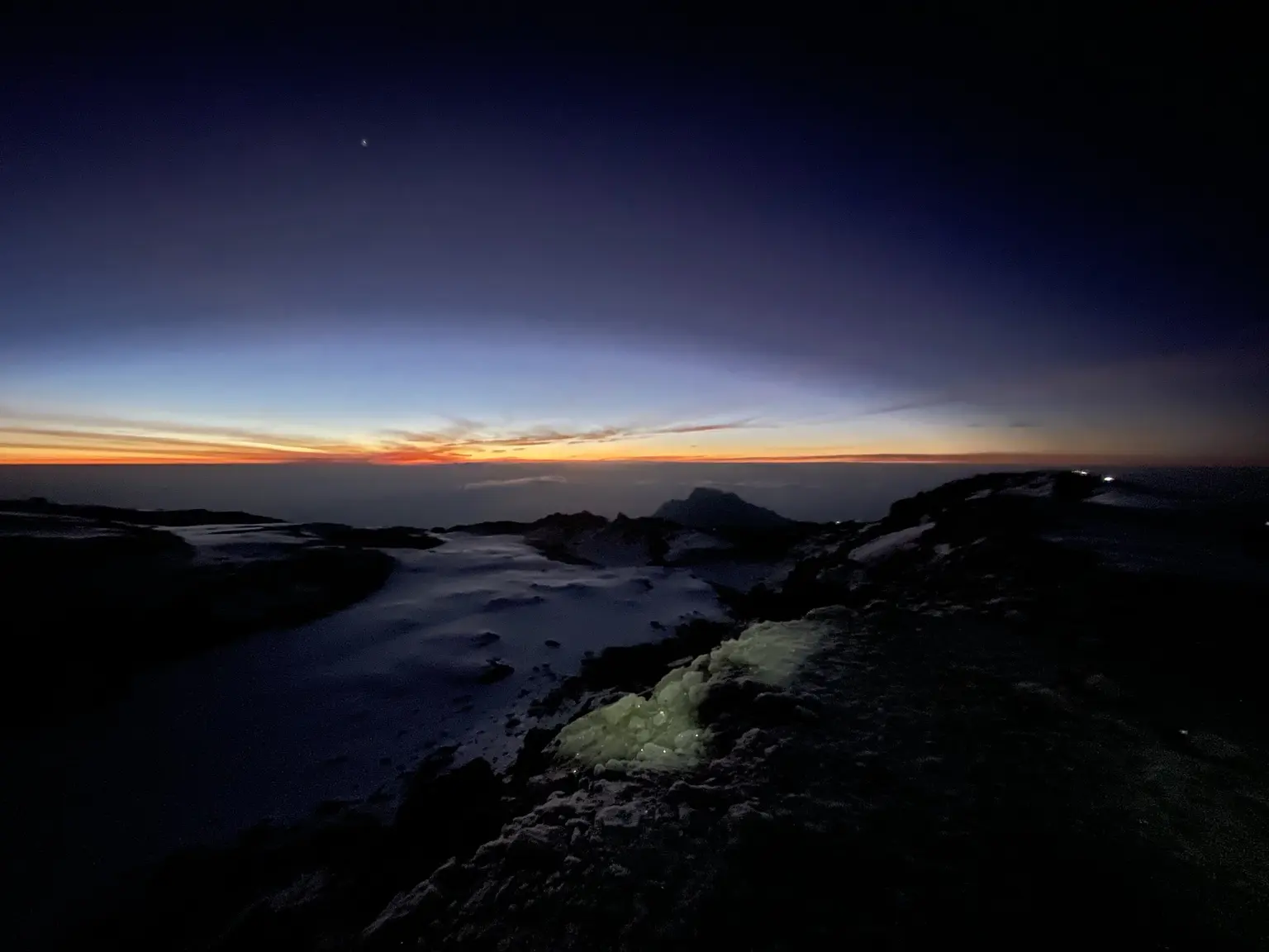 Dawn light above the clouds and snow on the upper slopes of Kilimanjaro.